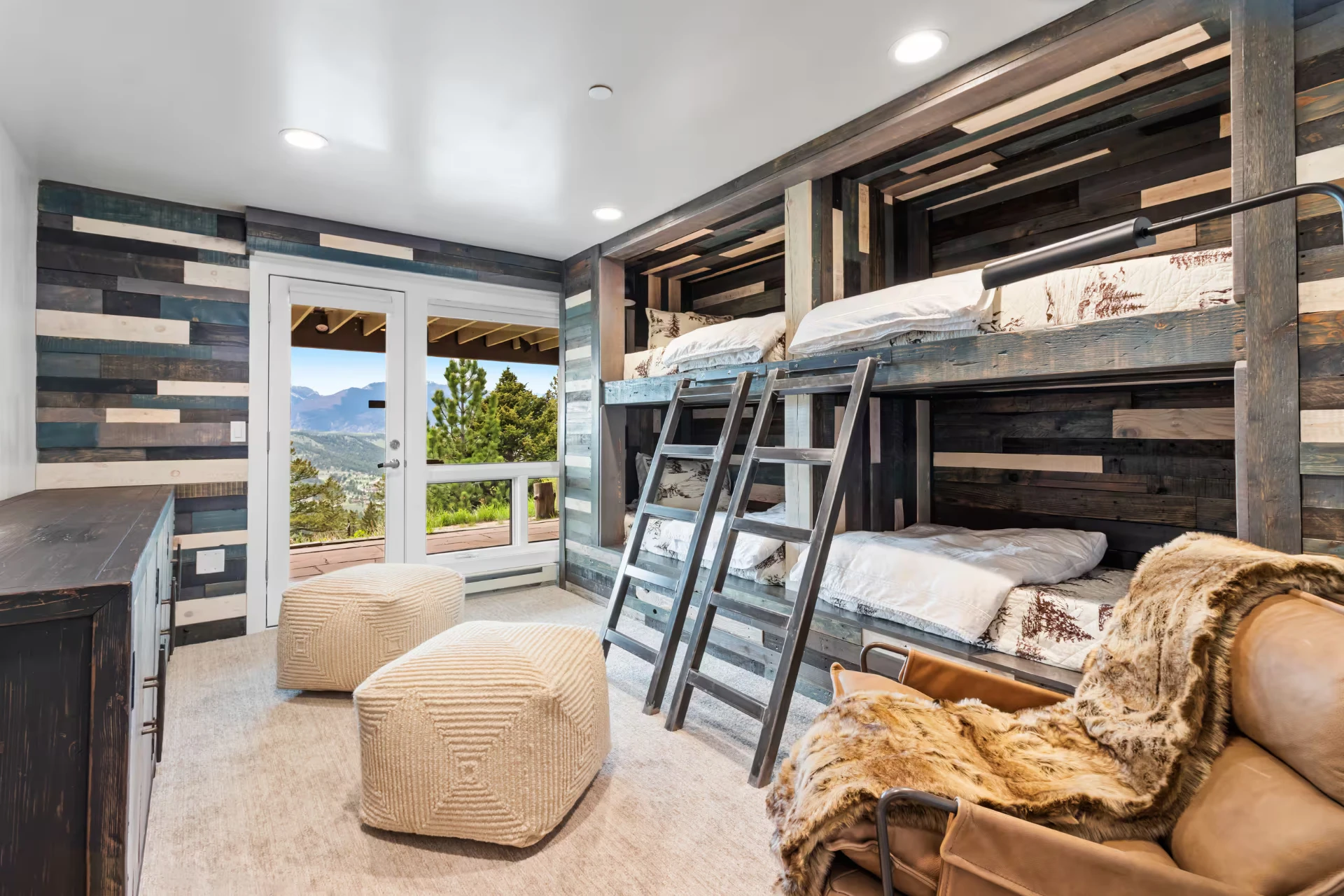 Bunk room with rustic wood walls and mountain views
