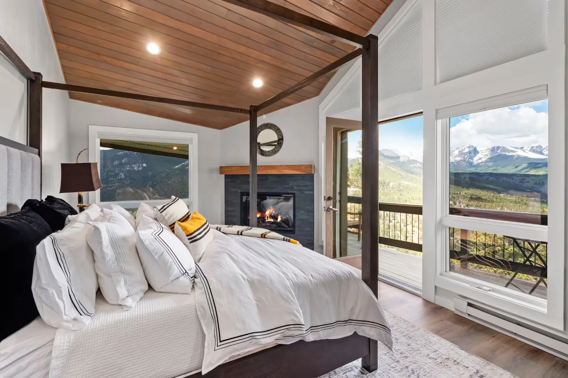 Master suite with four-poster bed, fireplace, and mountain views