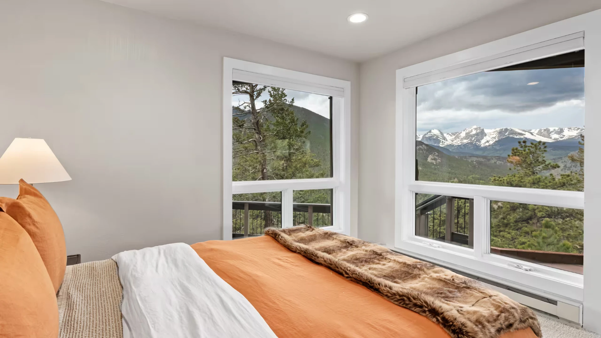 Bedroom with orange bedding and snow-capped mountain views